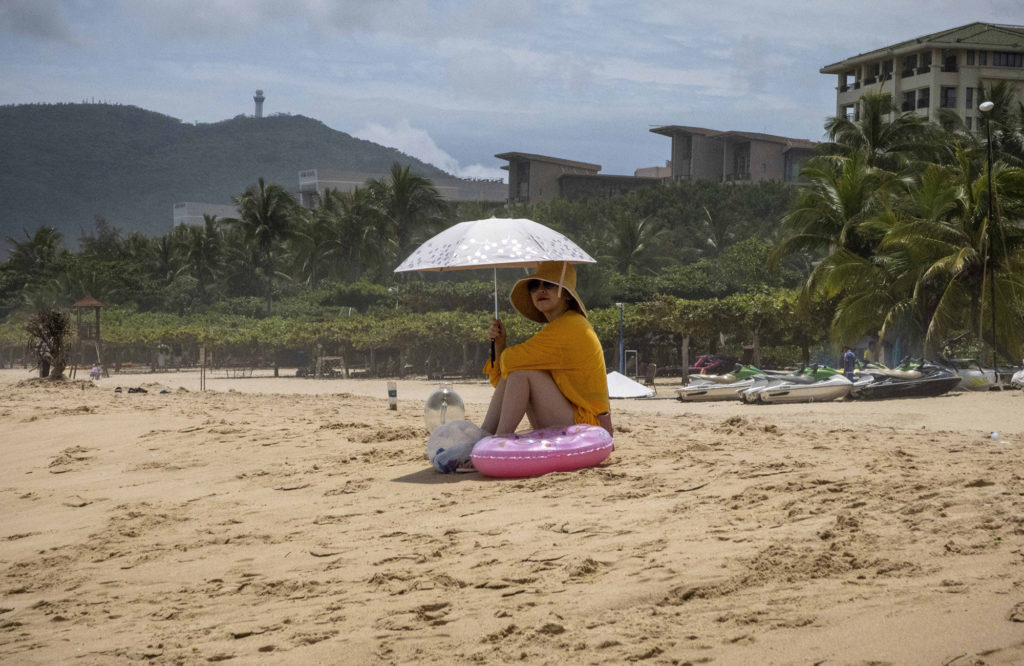 Touristin allein am Strand im Yalong Bay National Resort im Südosten von Sanya, Insel Hainan, Anfang August. Hainan – das Hawaii Chinas – ist insbesondere auch im Sommer bei einheimischen Touristen beliebt. Aufgrund von Covid-19 erlitt die Tourismusindustrie aber auch dort starke Einbrüche.  

Foto: imago images / ZUMA Wire (Wiktor Dabkowski)