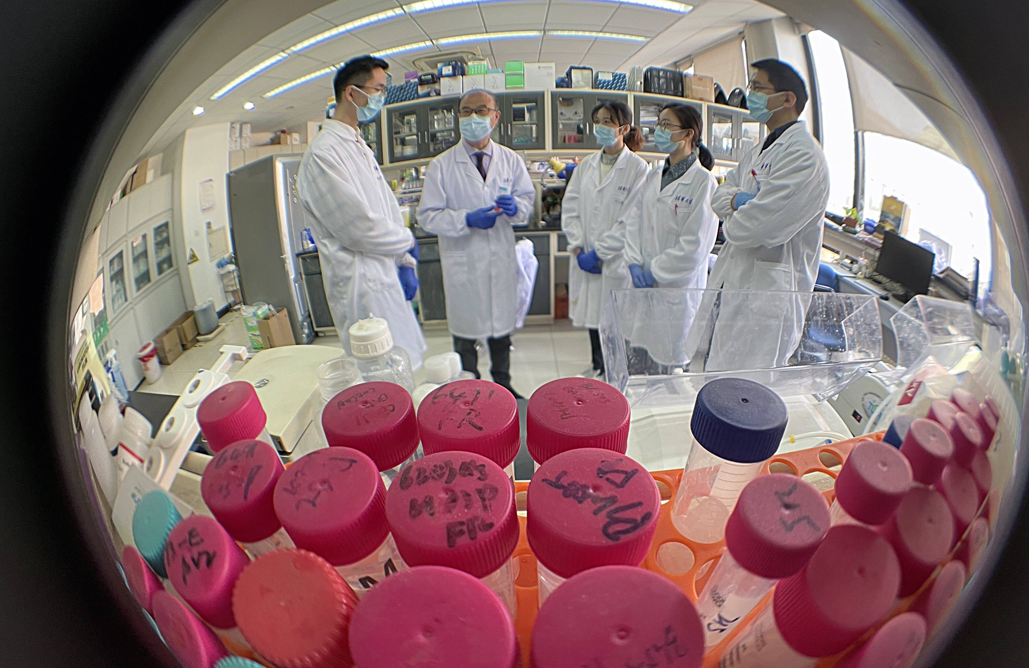 Zhang Linqi (2. von links), Professor an der Pekinger Tsinghua University School of Medicine, im Gespräch mit Studenten. Zhang widmet sich seit 30 Jahren der Erforschung der HIV-1-Pathogenese und der Entwicklung von Impfstoffen. Jetzt hat er innerhalb eines Jahres einen Impfstoff gegen Covid-19 entwickelt. Foto: MAGO / ZUMA Wire (Simon Song)